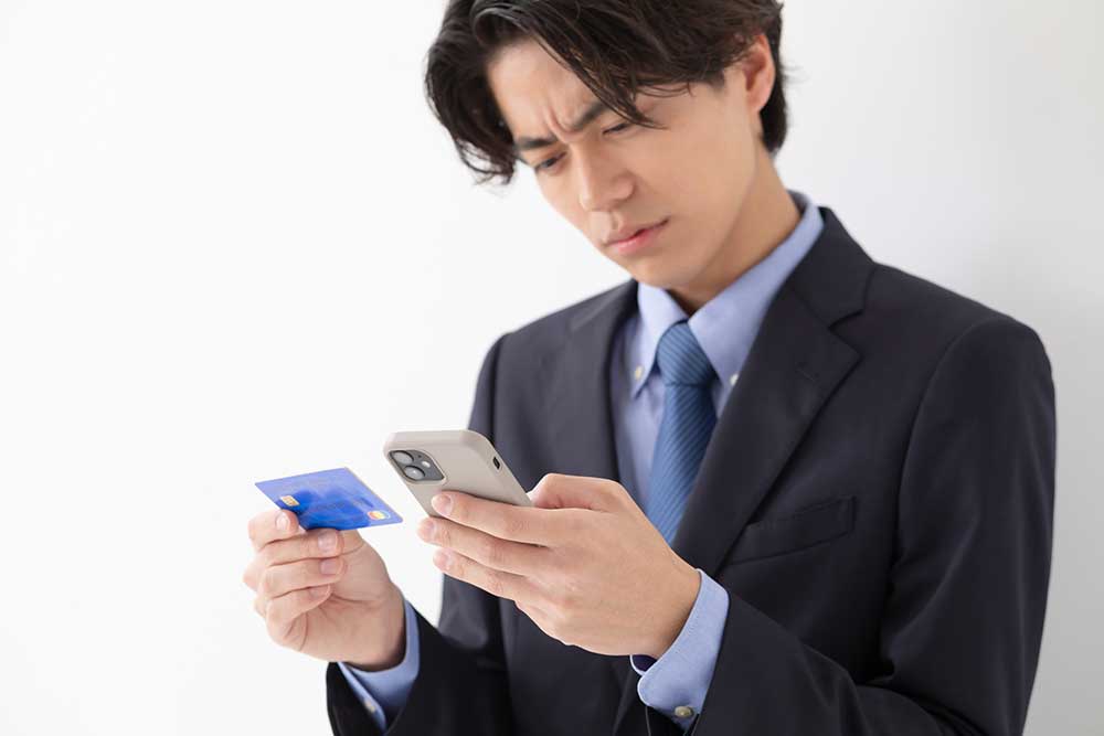 クレジットカードを見ながらメンズ医療脱毛の費用と支払い方法を考える男性